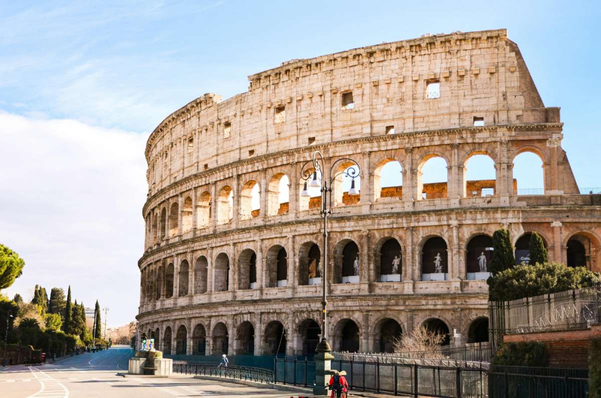a photo of the arched outer walls of the Colosseum on a sunny day, Rome, Italy