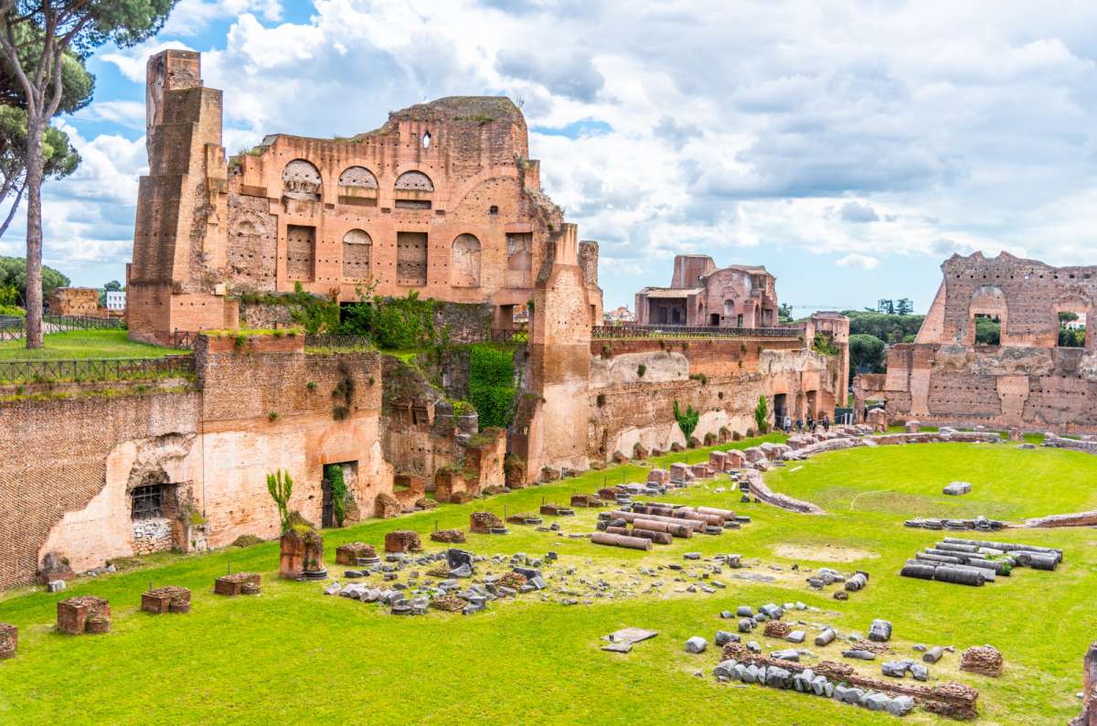a photo of the brick ruins of the imperial palaces and green lawns on Palatine Hill, Rome, Italy