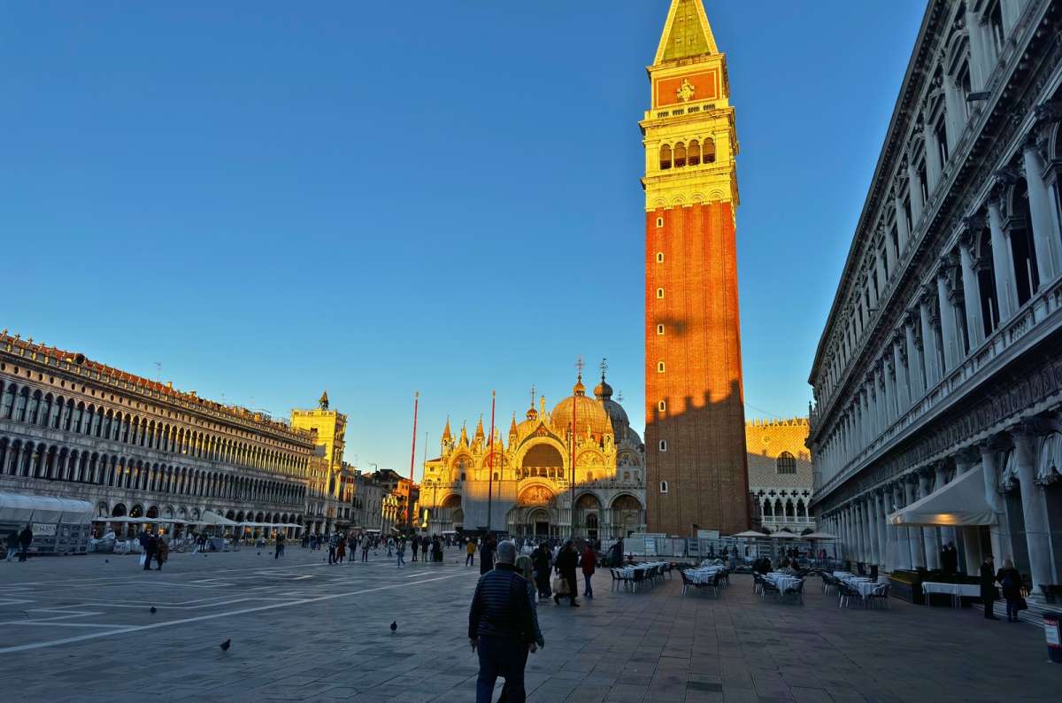 a photo of Piazza San Marco with St. Mark’s Campanile and St. Mark’s Basilica in the late afternoon sun, Venice, Italy, photo by Next Level of Travel