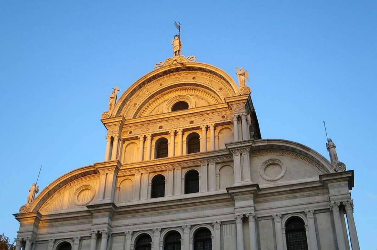 a photo of the white marble Renaissance facade of San Zaccaria Church in the late afternoon sun, Venice, Italy