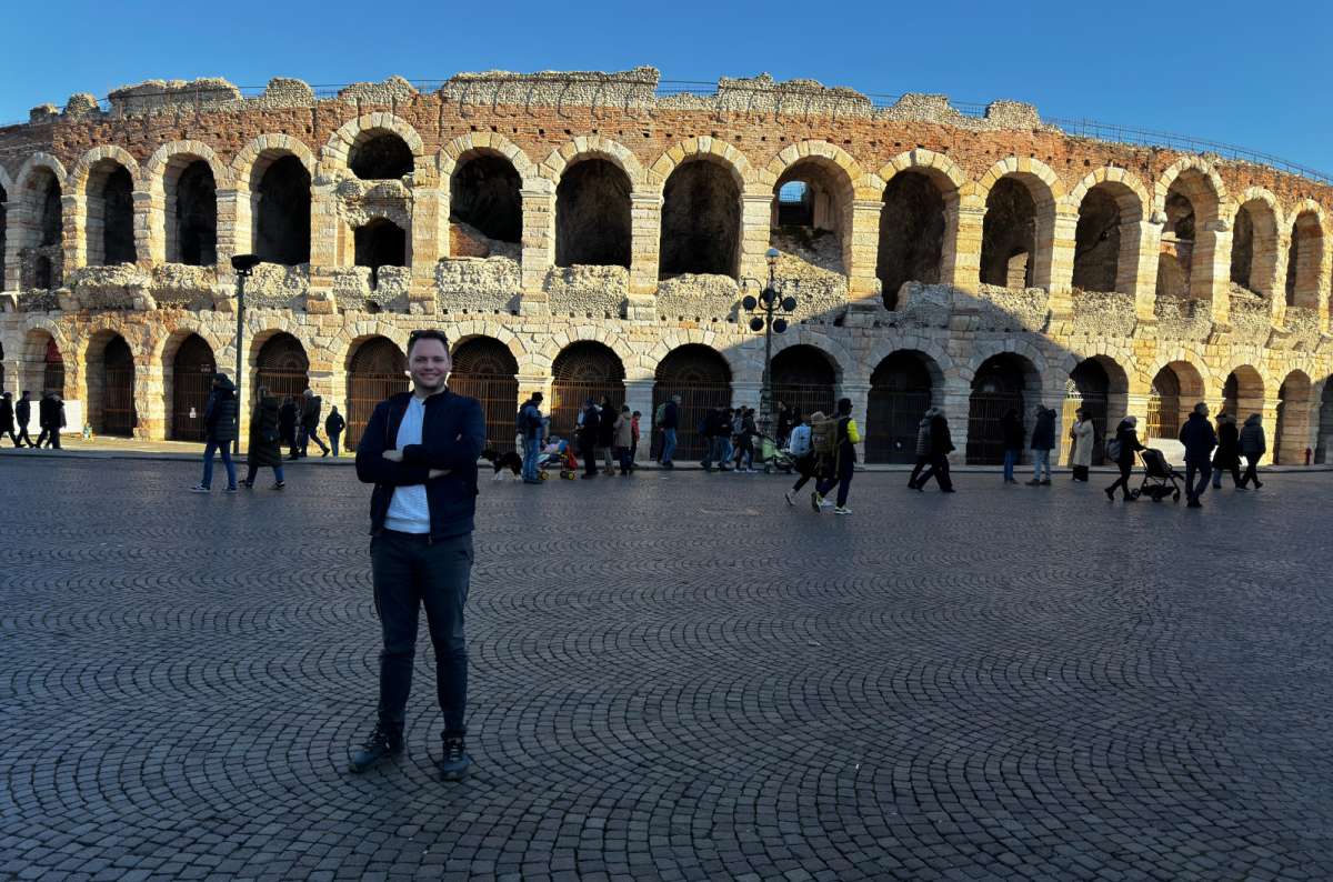 a photo of a tourist standing on the square in front of the Roman Arena, Verona, Italy, photo by Next Level of Travel