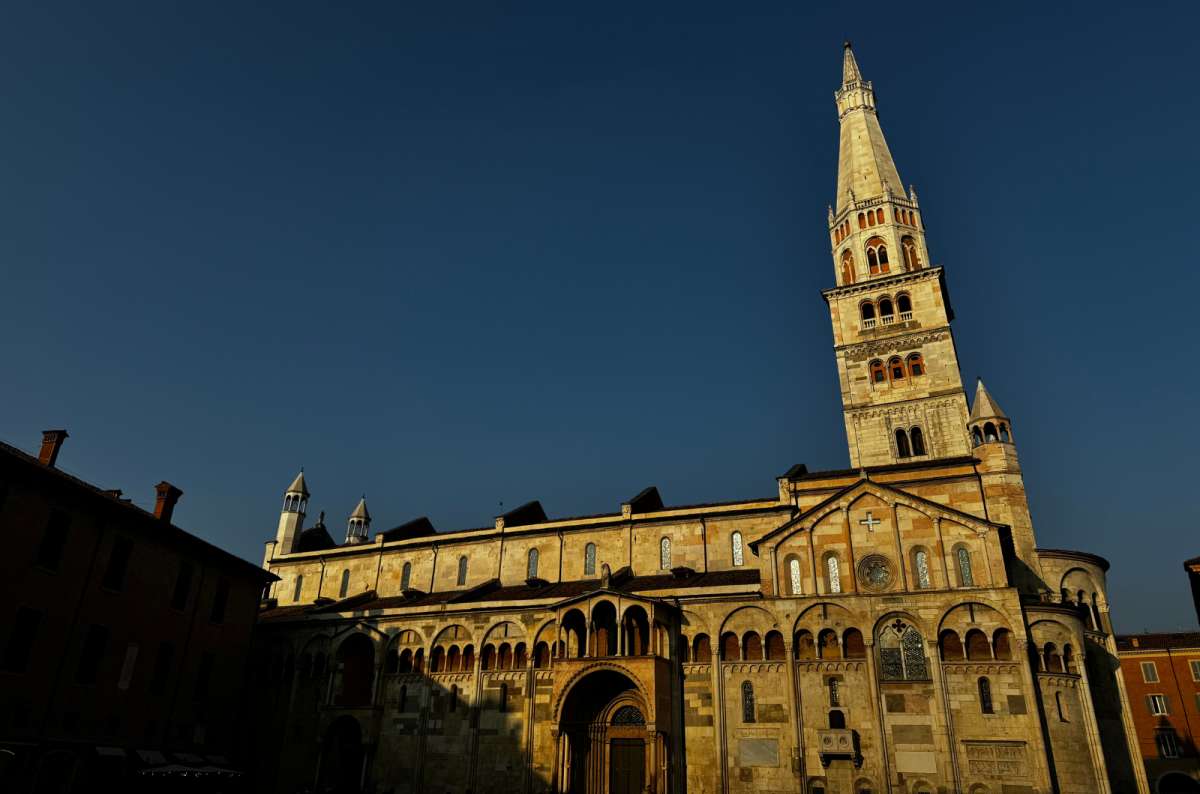 a photo of Modena Cathedral and the Torre Ghirlandina bell tower glowing in the late afternoon sun, Modena, Italy, photo by Next Level of Travel