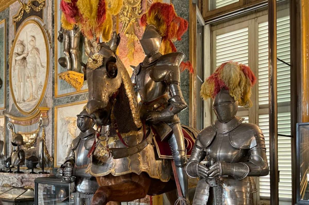 a photo of suits of armor on horseback with feathered helmets in the Royal Armory of the Royal Palace, Turin, Italy, photo by Next Level of Travel