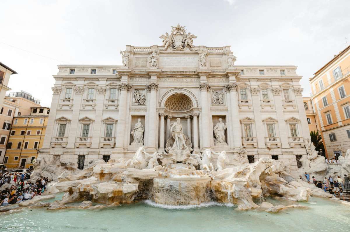 a photo of the Baroque Trevi Fountain with its marble statues and turquoise water, Rome, Italy