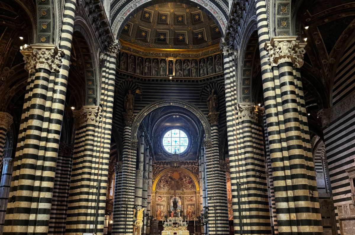 a photo of the black and white striped columns and nave inside Siena Cathedral, Siena, Tuscany, Italy, photo by Next Level of Travel
