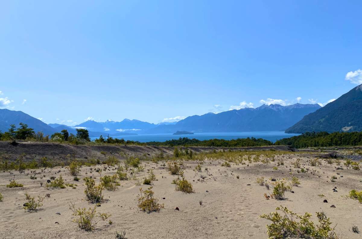 a photo of Lago Todos los Santos seen across volcanic sand on the slopes of Osorno volcano, Vicente Pérez Rosales National Park, Chile, photo by Next Level of Travel