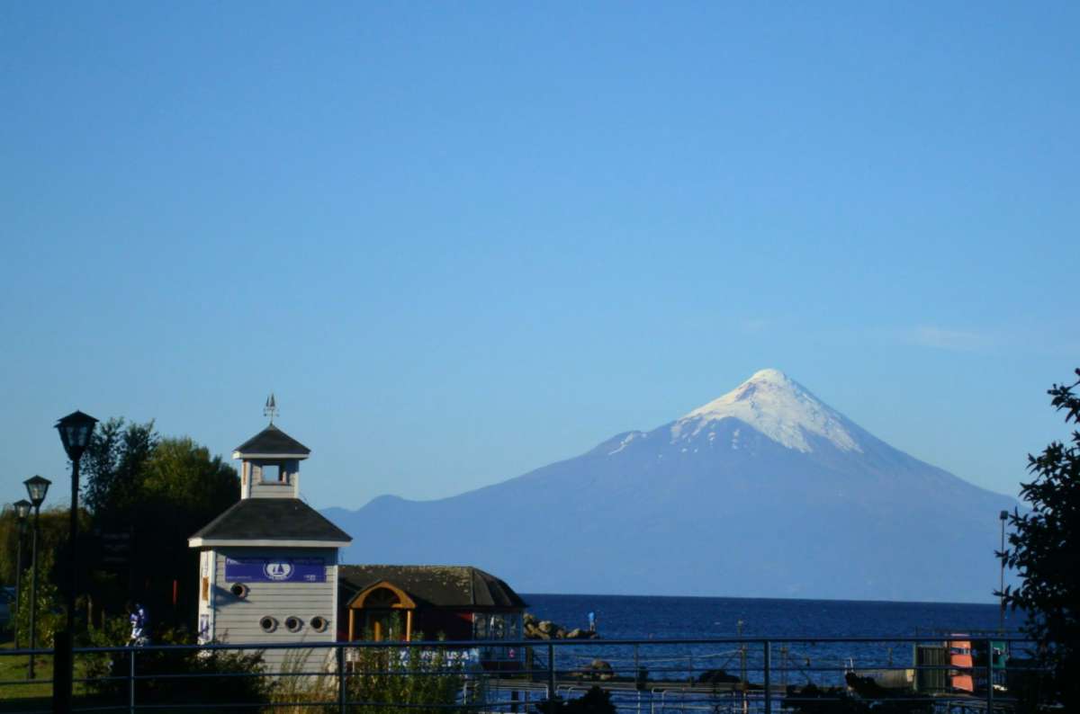 a photo of Osorno volcano rising above Lago Llanquihue from the Puerto Varas waterfront, Chile