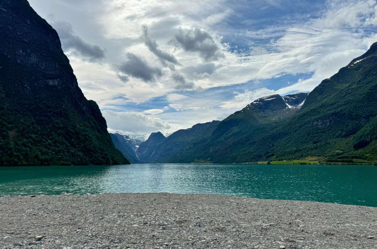 a photo of turquoise Lovatnet lake with a glacier at the end of the valley, Loen, Norway, photo by Next Level of Travel