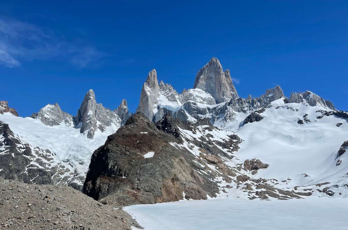 Frozen Laguna de los Tres with Mount Fitz Roy rising behind snow-covered rocky terrain in Los Glaciares National Park, Argentina, photo by Next Level of Travel