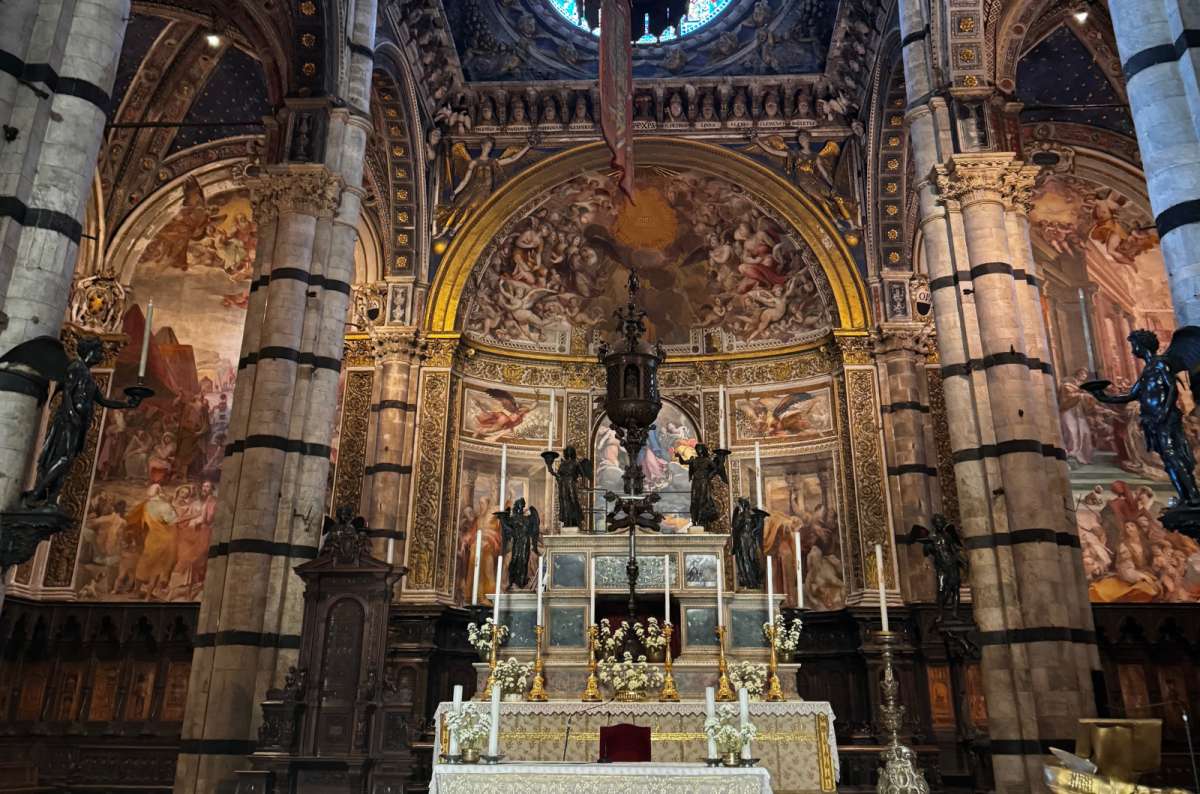 a photo of the high altar and striped black and white marble columns inside Siena Cathedral, Siena, Italy, photo by Next Level of Travel