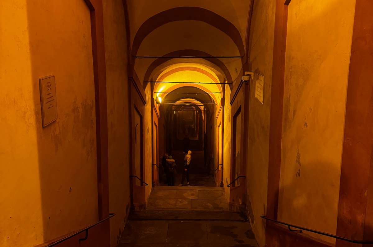 a photo of the lit arches and steps of the San Luca portico at night, Bologna, Italy, photo by Next Level of Travel