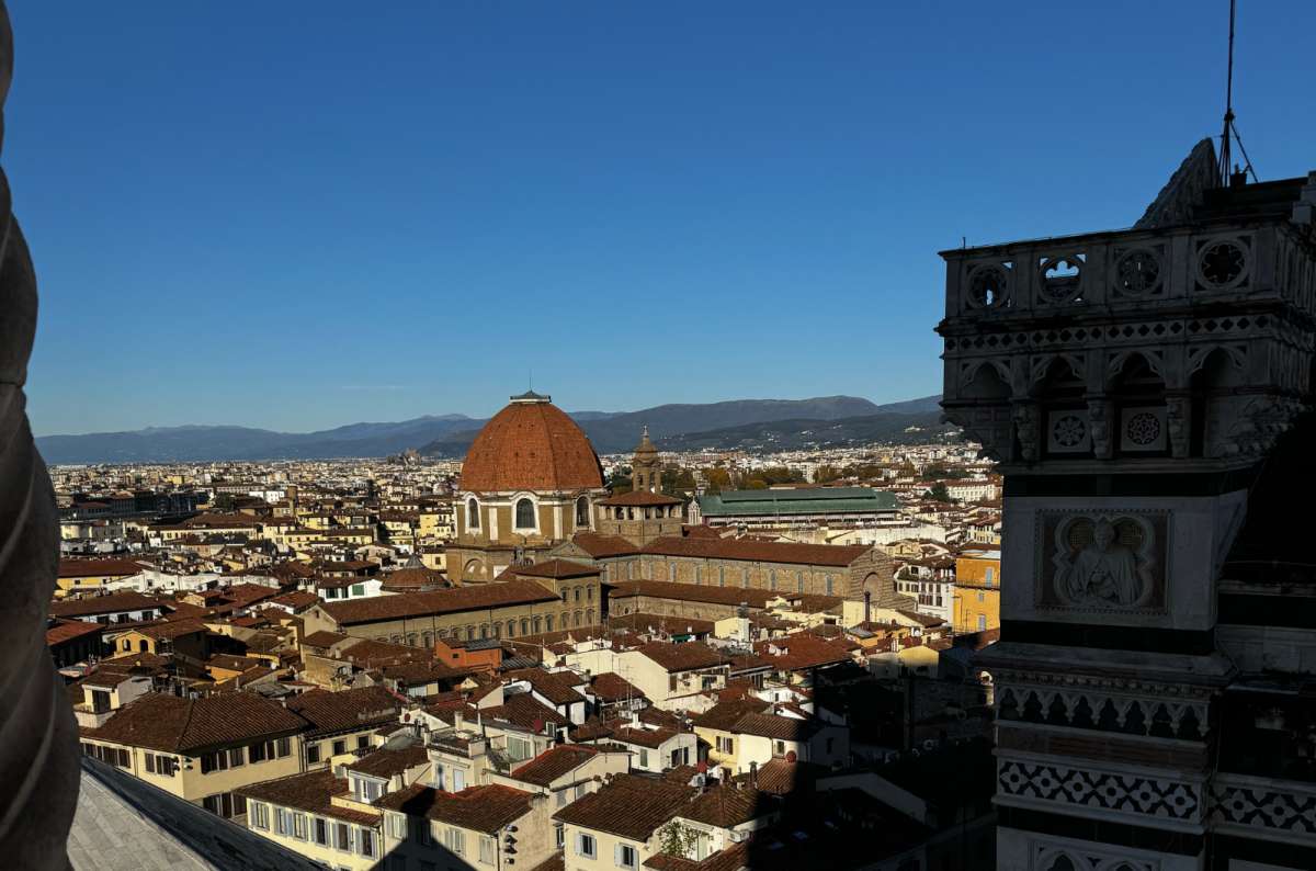 a photo of the rooftops of Florence and the red dome of San Lorenzo seen from high above Piazza del Duomo, Florence, Italy, photo by Next Level of Travel