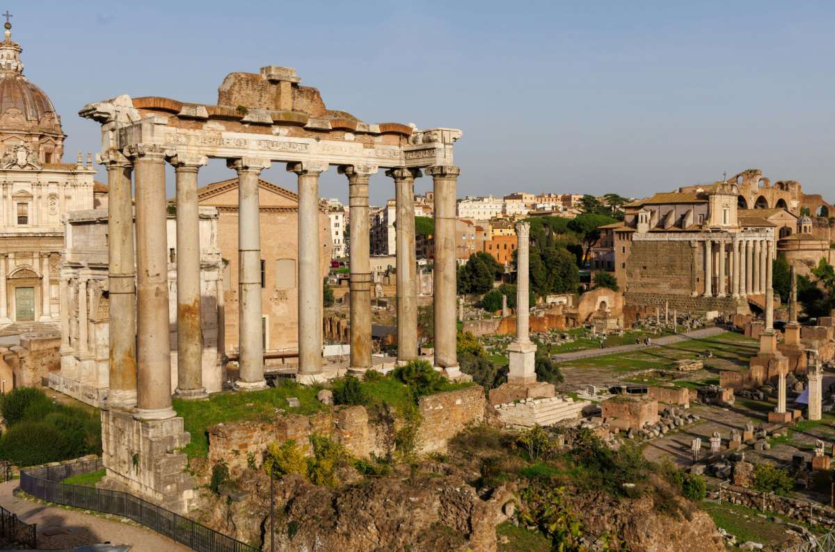 a photo of the ruins of the Roman Forum with the columns of the Temple of Saturn, Rome, Italy