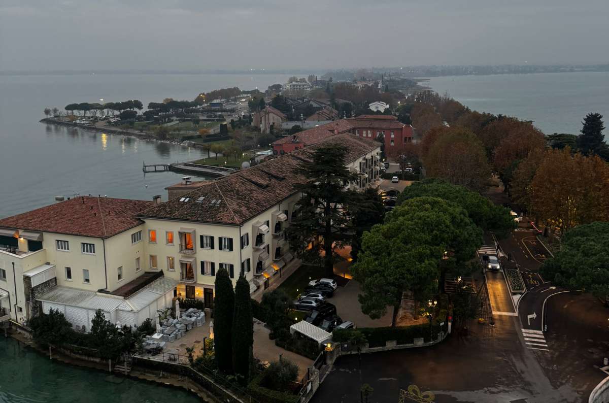 a photo of the Sirmione peninsula stretching into Lake Garda seen from the tower of Scaliger Castle, Sirmione, Italy, photo by Next Level of Travel