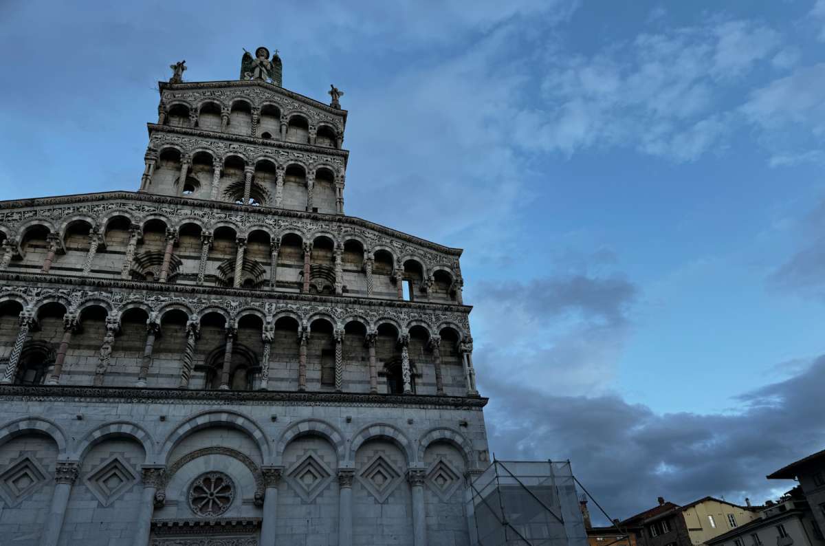 a photo of the white marble facade of the Church of San Michele in Foro under an evening sky, Lucca, Italy, photo by Next Level of Travel