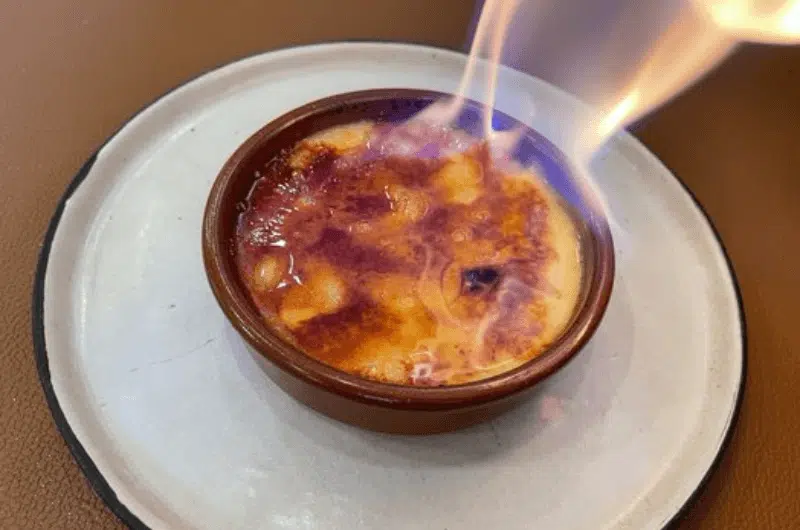 A crème brulee with flames at a Belgian restaurant 