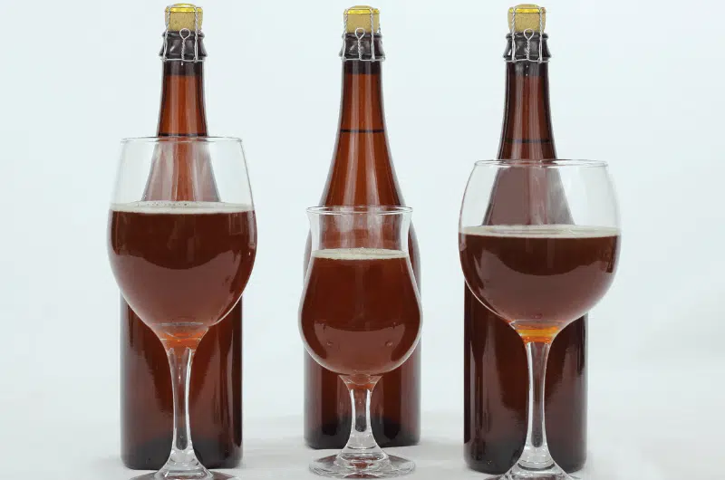Three bottles and glasses of lambic beer, best beer in Belgium