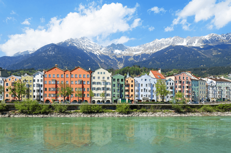 Mariahilfestrasse with the famous colorful houses in Innsbruck with Alps in the background